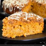 Slice of carrot coffee cake on a dark plate.