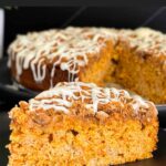 Slice of carrot coffee cake on a dark plate.