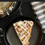 Slice of carrot coffee cake on a dark plate.