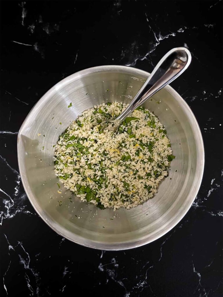 A bowl containing chicken piccata meatball mixture.