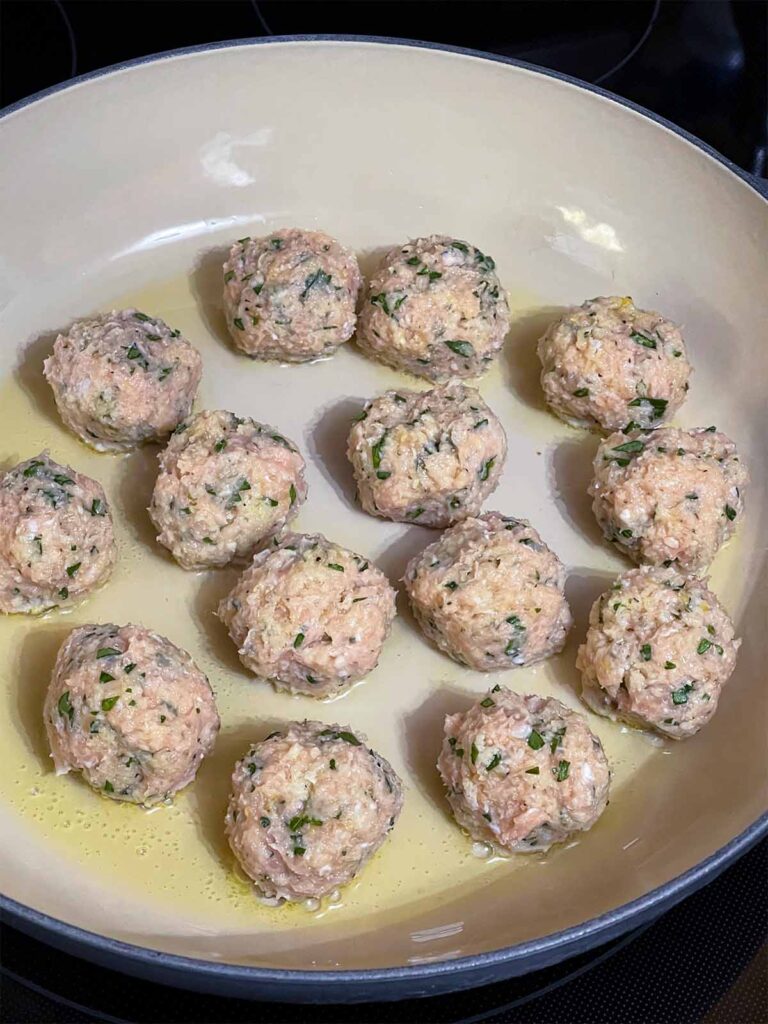 Chicken Piccata Meatballs cooking in a skillet.