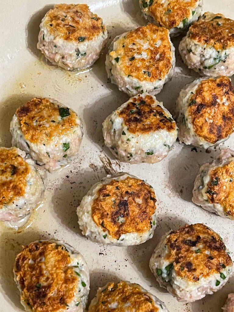 Chicken Piccata Meatballs cooking in a skillet.