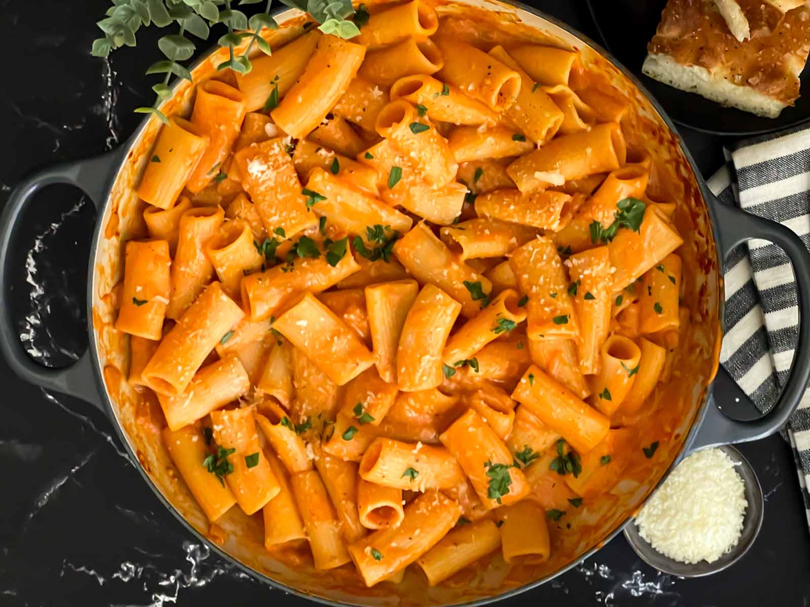 Pasta alla Vodka in a round cast iron skillet garnished with parsley.