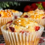 Strawberry muffins on a wire cooling rack on a dark surface.