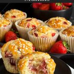 Two strawberry muffins on a dark plate on a dark surface.