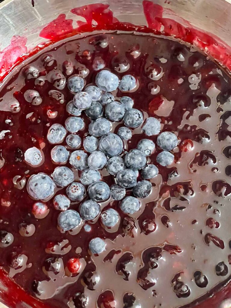 Blueberry filling ingredients in a metal saucepan for the berry poke cake recipe.