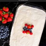 Berry poke cake on a dark surface.