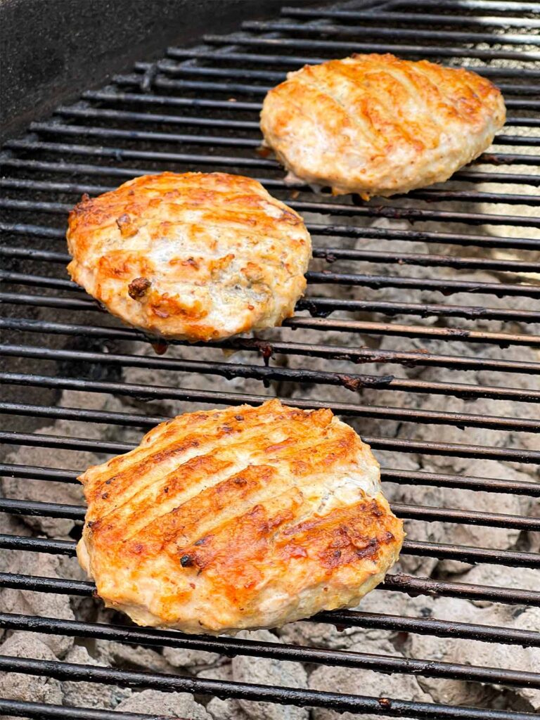 Grilled chicken burgers on the grill.