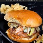 Carolina Grilled Chicken Burger on a black plate with potato chips.