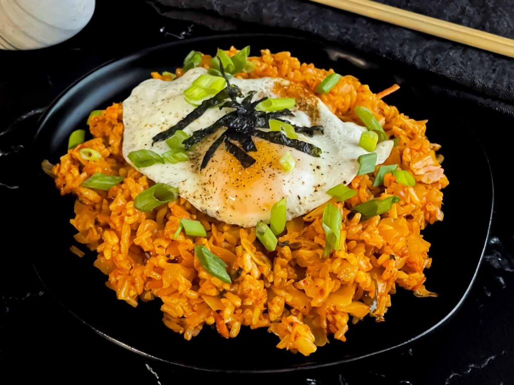 Kimchi fried rice topped with green onion, and gim.