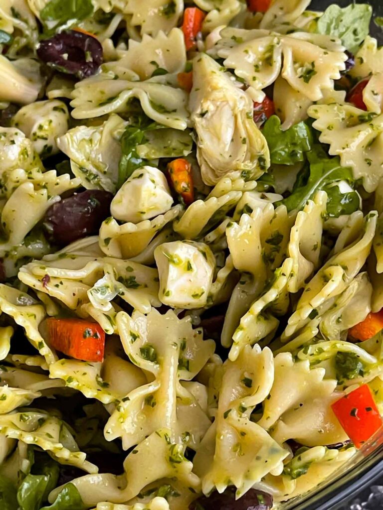 Mediterranean pasta salad mixed in a glass bowl.