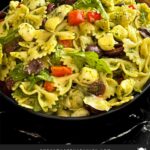 Mediterranean pasta salad mixed in a dark bowl.