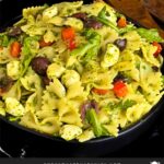 Mediterranean pasta salad mixed in a dark bowl.