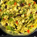 Mediterranean pasta salad mixed in a glass bowl.