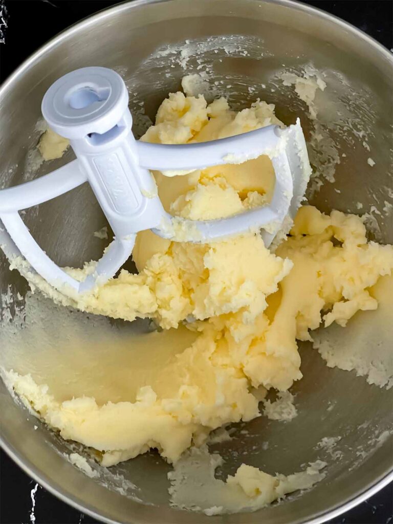 Creamed butter and sugar in a metal mixing bowl for the peach pound cake recipe.