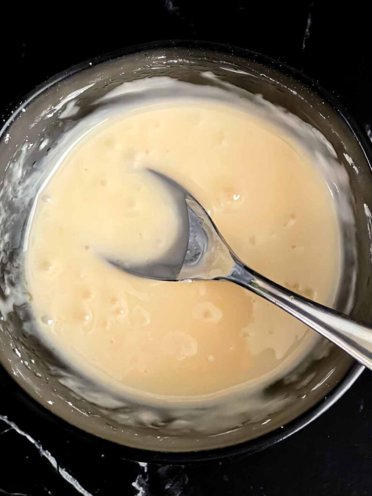 Peach glaze mixed in a small dark bowl.