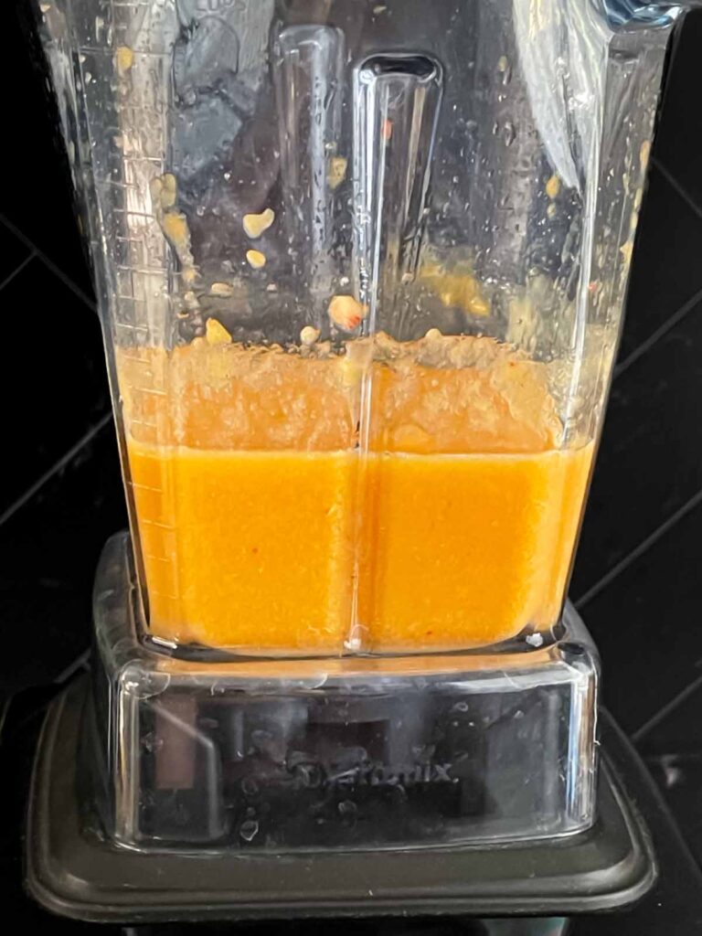 Peach puree in a blender on a dark surface.