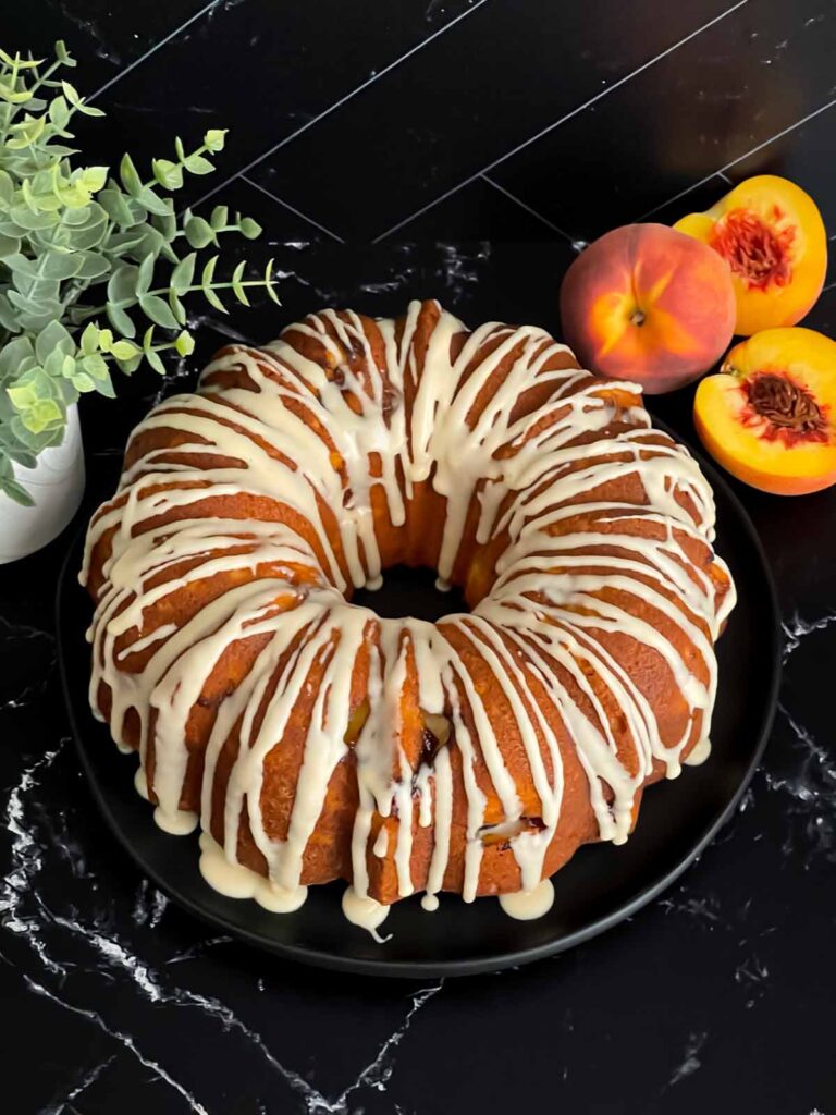 Peach pound cake on a dark plate on a dark surface.