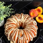 Peach pound cake on a dark plate on a dark surface.