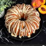 Peach pound cake on a dark plate on a dark surface.