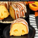 Peach pound cake on a dark plate on a dark surface.