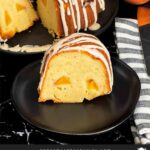 Peach pound cake on a dark plate on a dark surface.