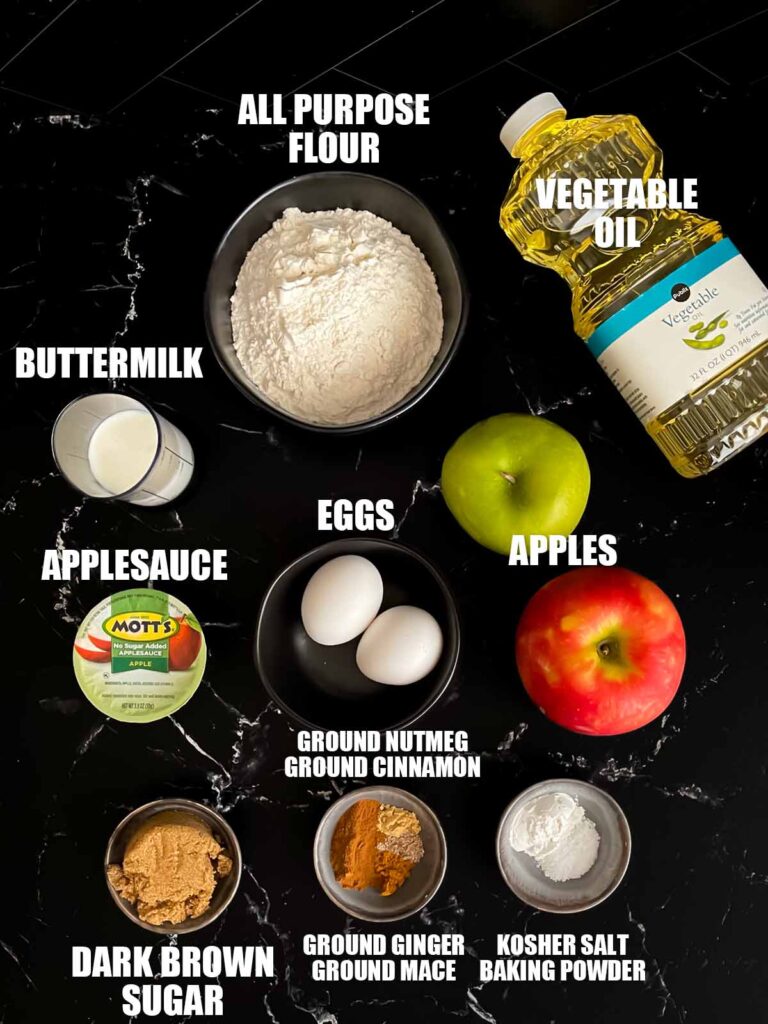 Apple fritters recipe ingredients on a dark surface.