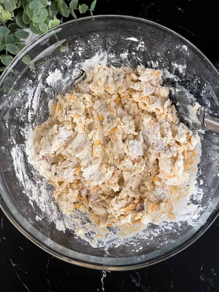 Bacon cheddar biscuit dough mixed in a glass mixing bowl.