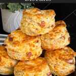 Bacon cheddar biscuits stacked on a dark plate.