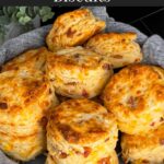 Bacon cheddar biscuits stacked in a towel lined bread basket.