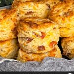 Bacon cheddar biscuits stacked in a towel lined bread basket.