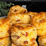 Bacon cheddar biscuits stacked in a towel lined bread basket.