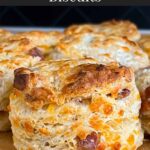 Bacon cheddar biscuits on a parchment paper lined baking sheet.