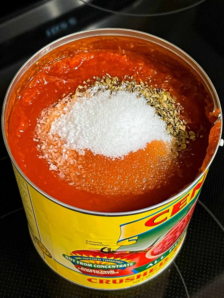 Ingredients added to a can of crushed tomatoes for a calzone dipping sauce.