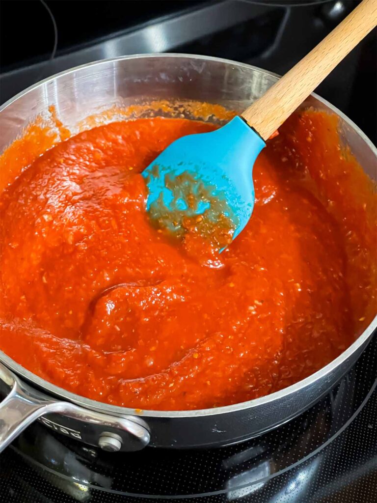 Dipping sauce for a calzone in a saucepan cooking.