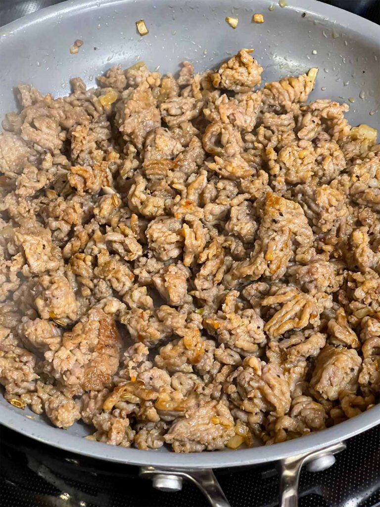 Italian sausage cooked in a skillet.