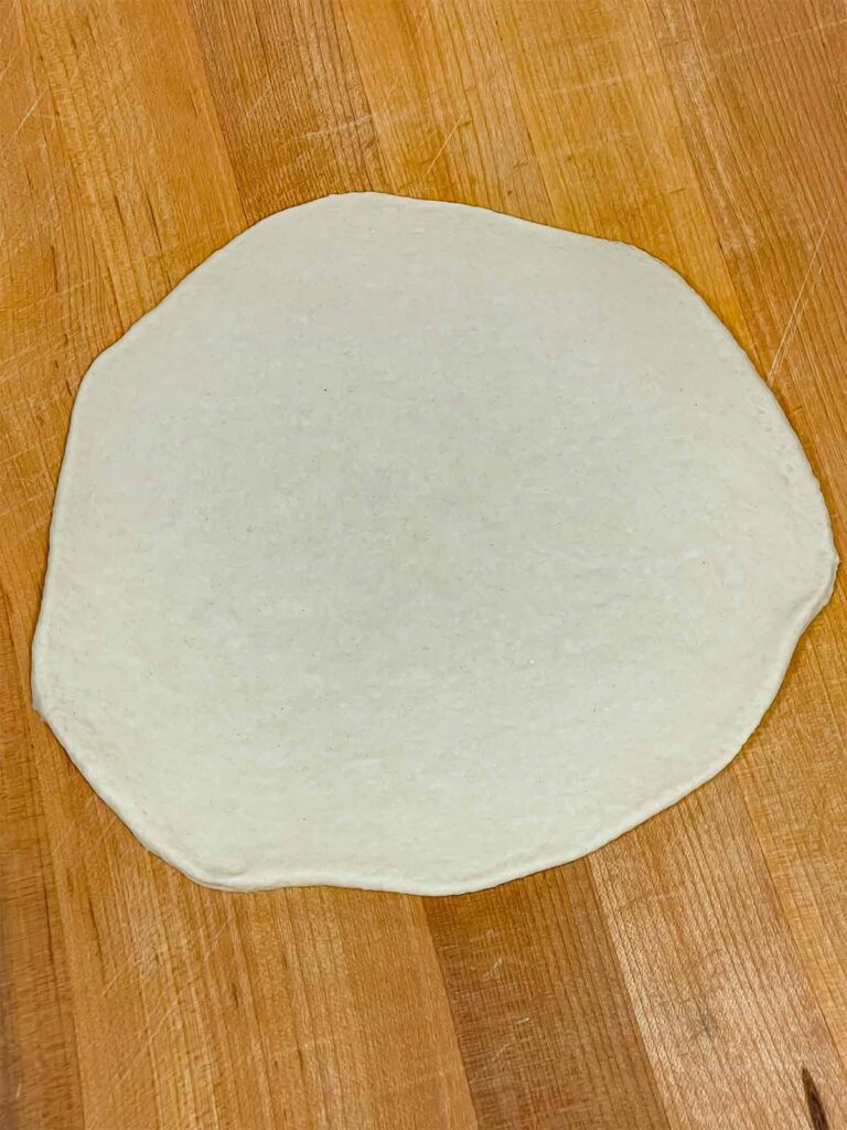 Dough for a calzone rolled out.