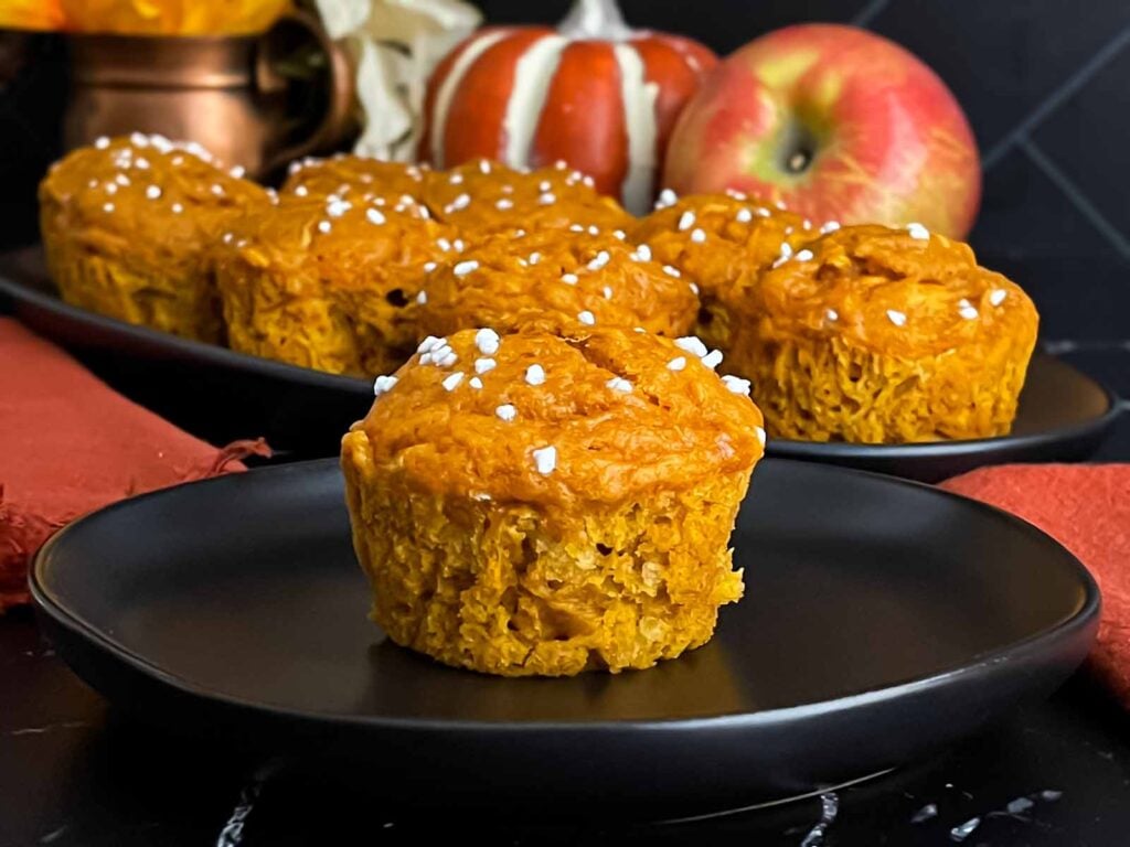 Pumpkin apple muffin on a dark plate.