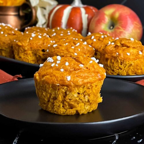 Pumpkin apple muffin on a dark plate.