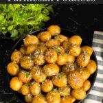 Slow cooker garlic parmesan potatoes in a dark bowl garnished with parsley and parmesan cheese.