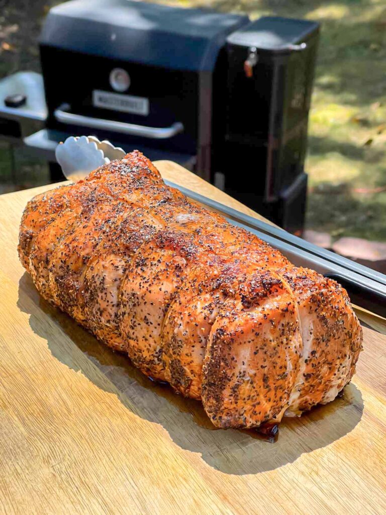 A Texas style smoked pork loin on cutting board.