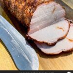 A Texas style smoked pork loin on cutting board with some slices.