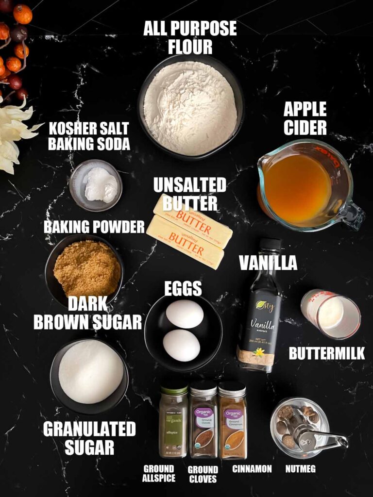 Apple cider muffins recipe ingredients on a dark surface.