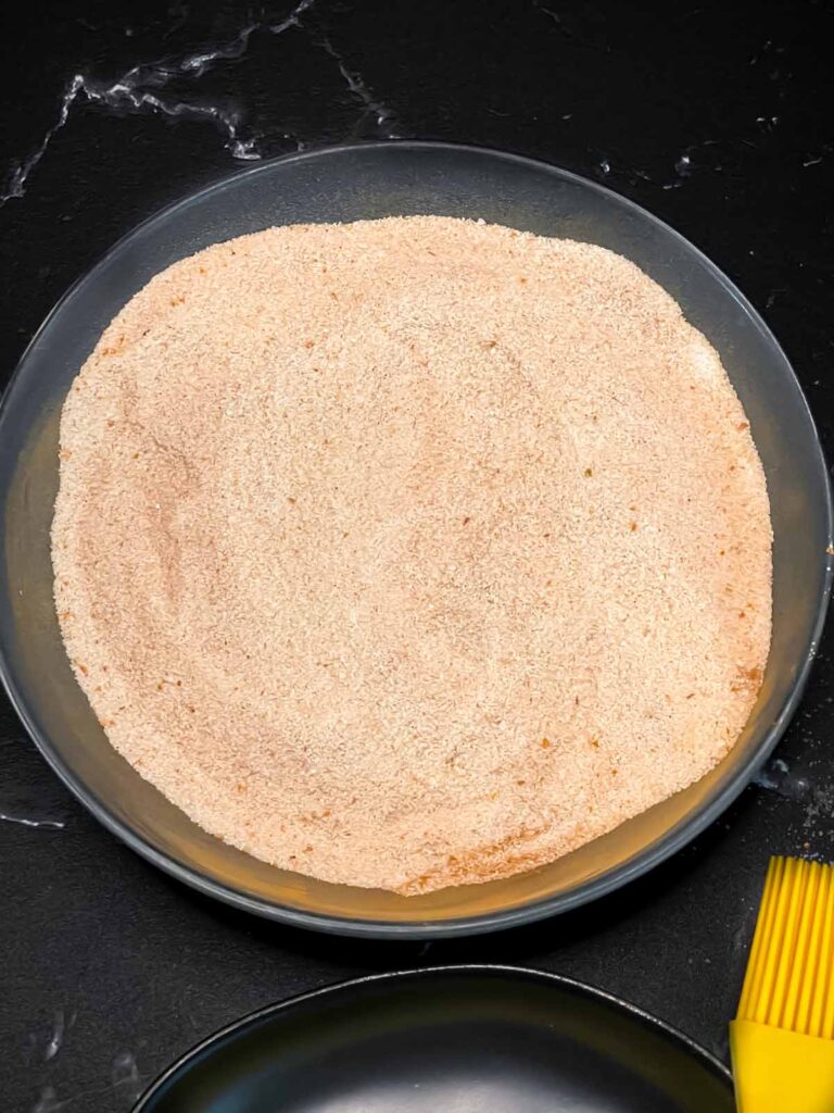 Cinnamon sugar mixture in a shallow dark bowl.