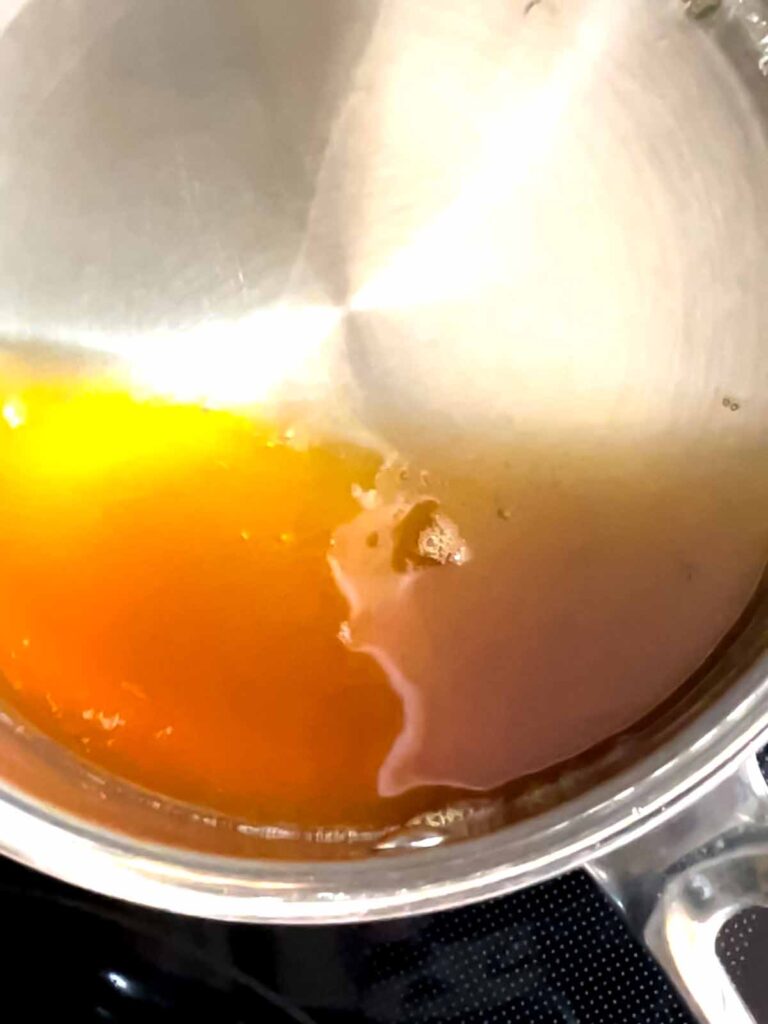 Reduced apple cider in a small sauce pan.