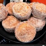 Apple cider muffins stacked on a dark plate.