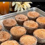 Apple cider muffins on a wire rack over a baking sheet.