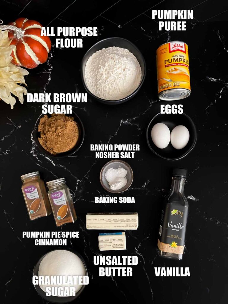 Baked pumpkin donuts recipe ingredients on a dark surface.