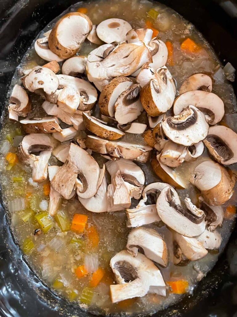 Mushrooms add to the slow cooker with chicken and wild rice soup ingredients.