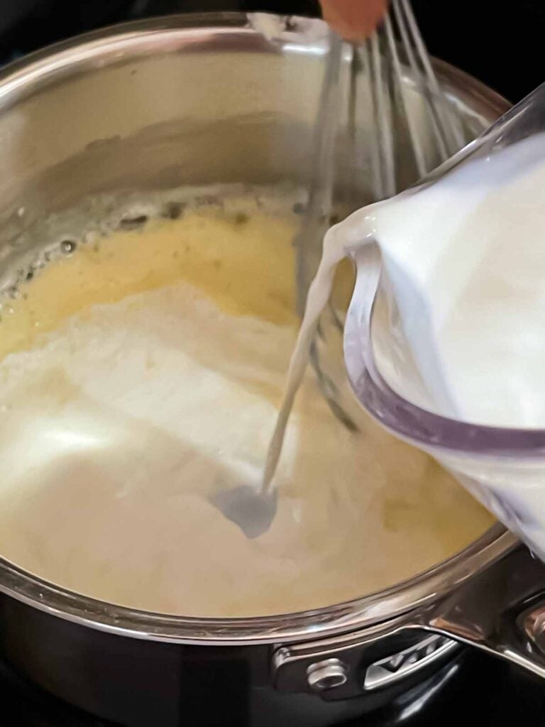 Milk being added slowly to the roux for chicken and wild rice soup.